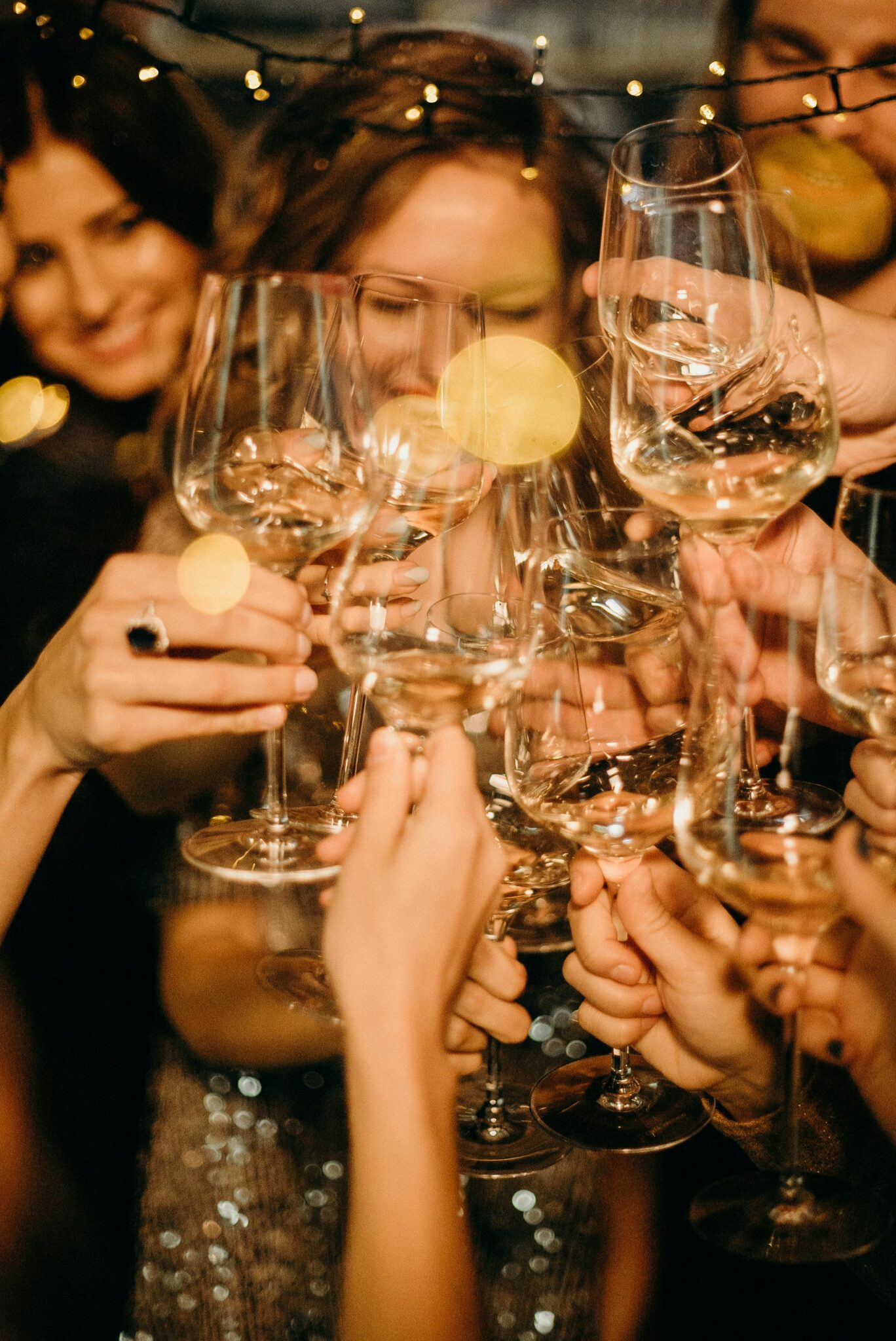 Group of people toasting with champagne glasses during a festive New Year's Eve party.